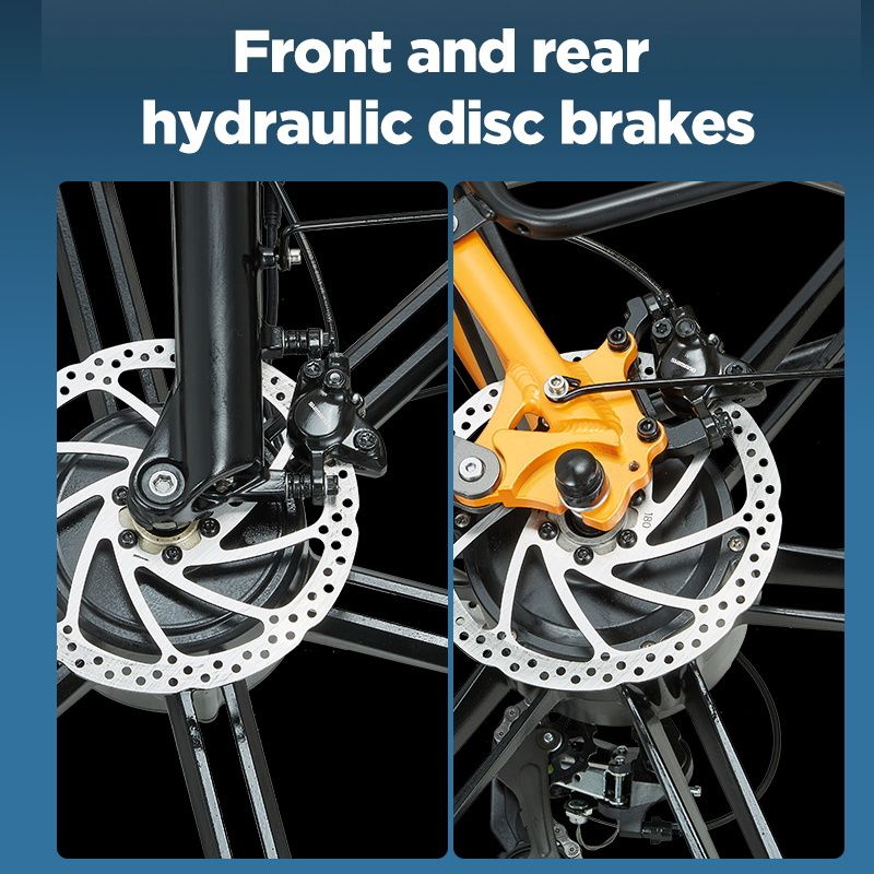 Hydraulische Scheibenbremsen vorne und hinten. Silberne Bremsscheiben, schwarze Bremssättel, gelber Rahmen.