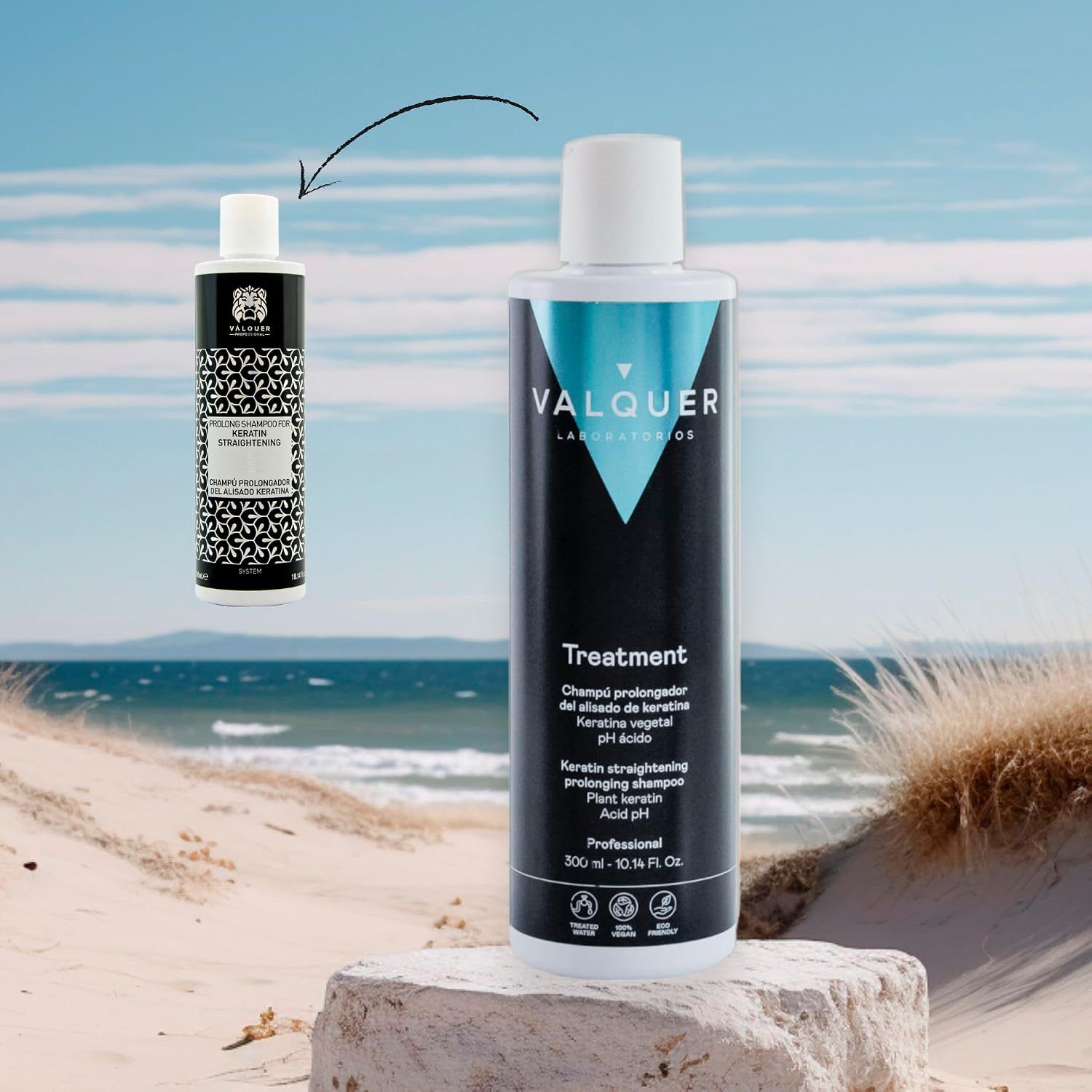 Eine schwarze Flasche Valquer Treatment Shampoo steht auf einem blauen Handtuch, umgeben von grünen Blättern und einer Haarbürste.