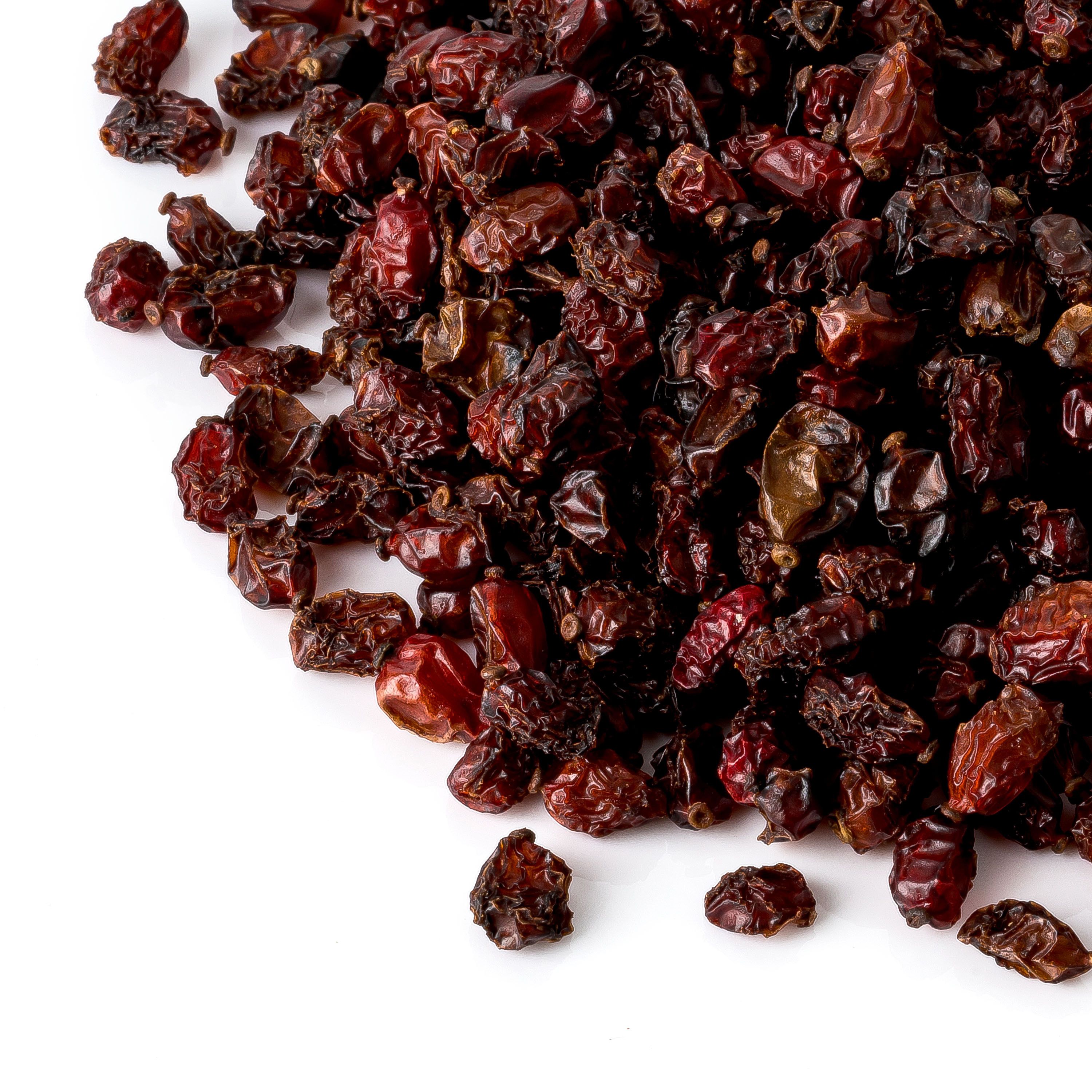 Haufen Berberitzen auf weißem Hintergrund. Dunkelrote, getrocknete Beeren. Nahaufnahme.