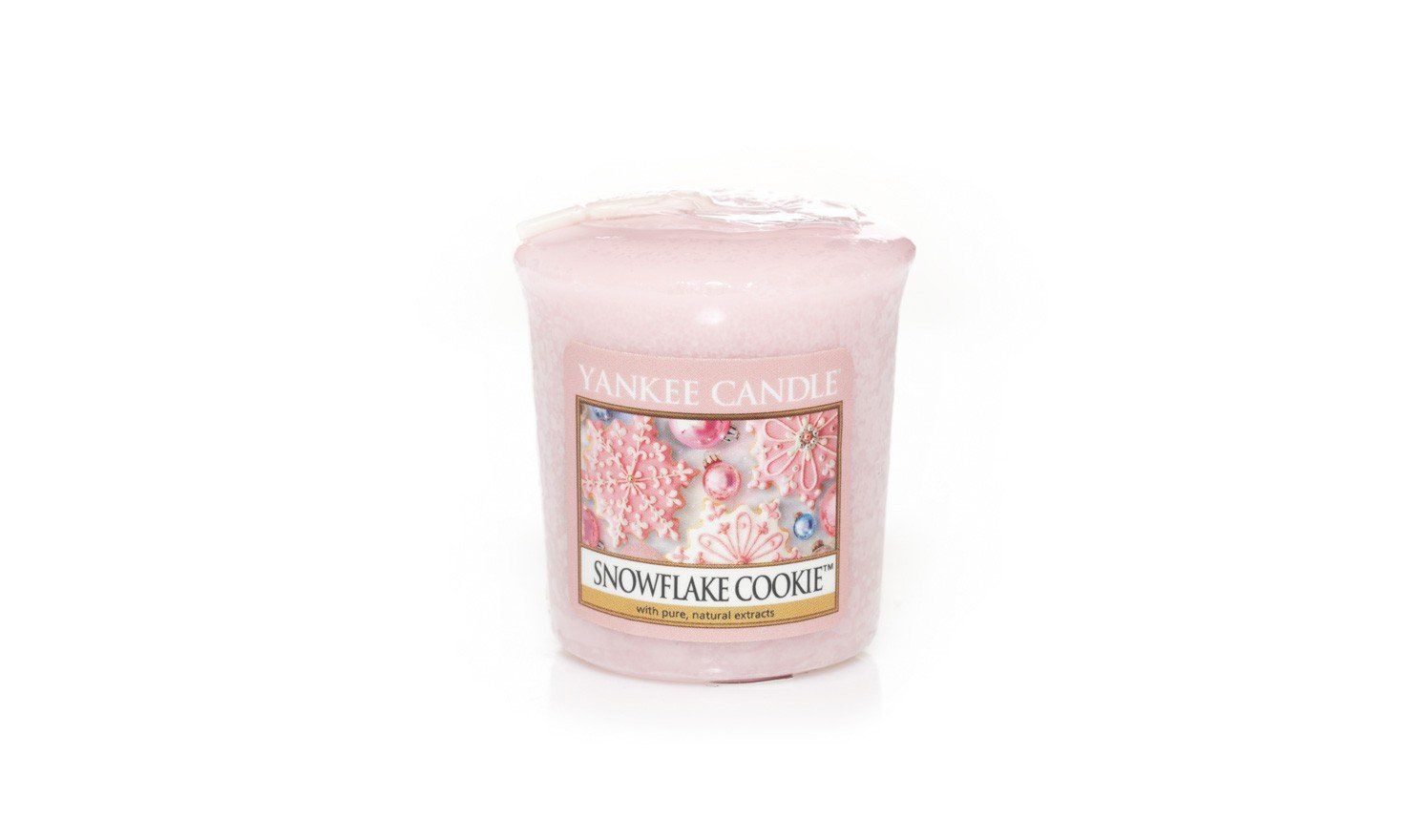 Rosa Kerzenglas mit Etikett. Aufschrift: Yankee Candle, Snowflake Cookie. Florales Design.