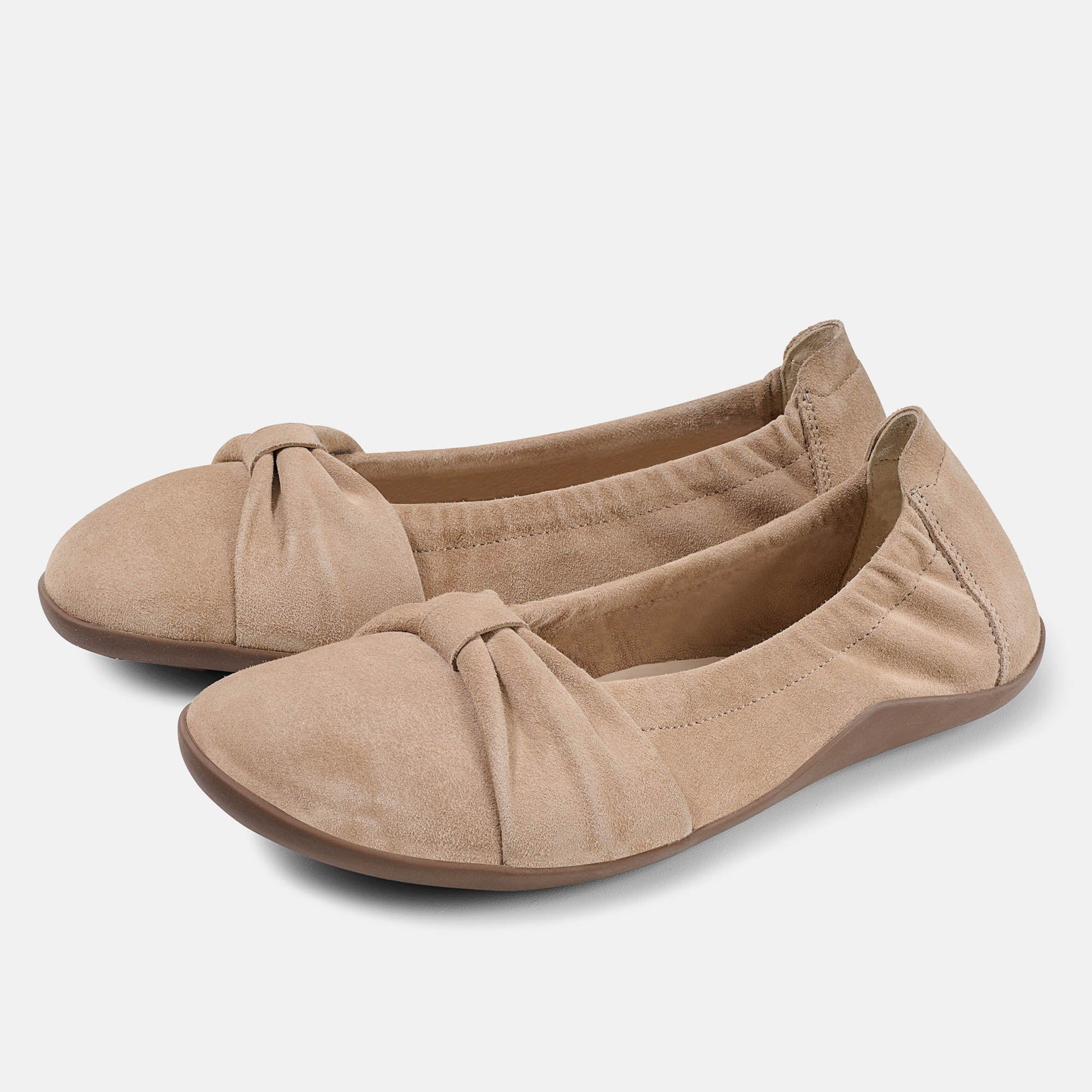 Bequeme Ballerinas aus beigem Wildleder mit Schleifenverzierung und Gummisohle.