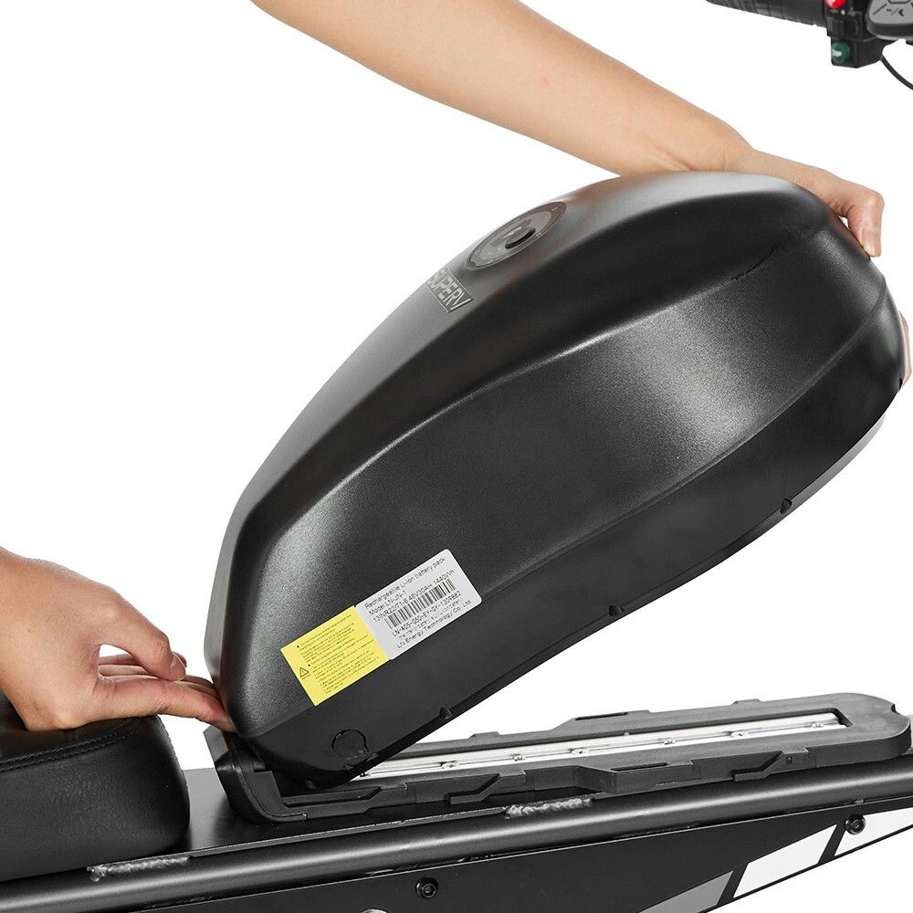 Person legt einen schwarzen Akku in das Gehäuse. Schwarzes Gehäuse mit Aufklebern.