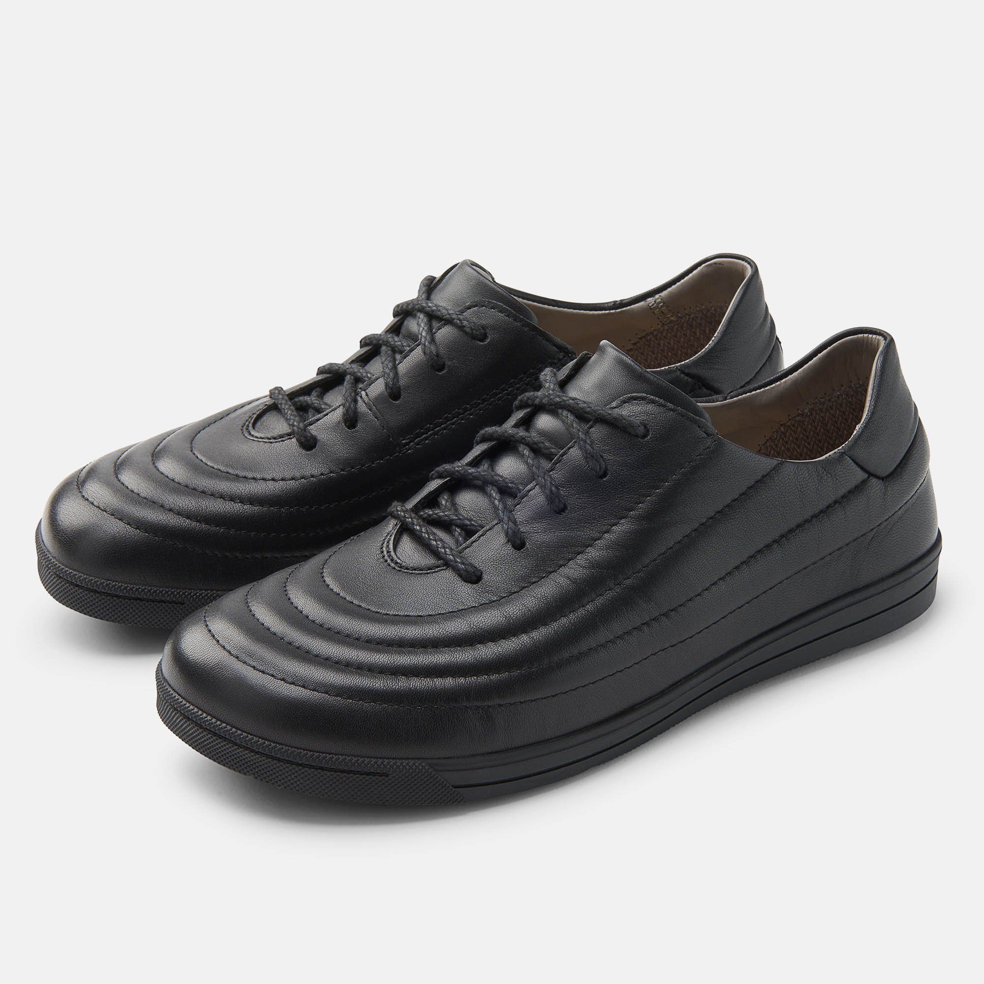 Zwei schwarze Schnürschuhe. Obermaterial mit horizontalen Nähten. Schwarze Schnürsenkel. Sohle und Obermaterial aus Leder.