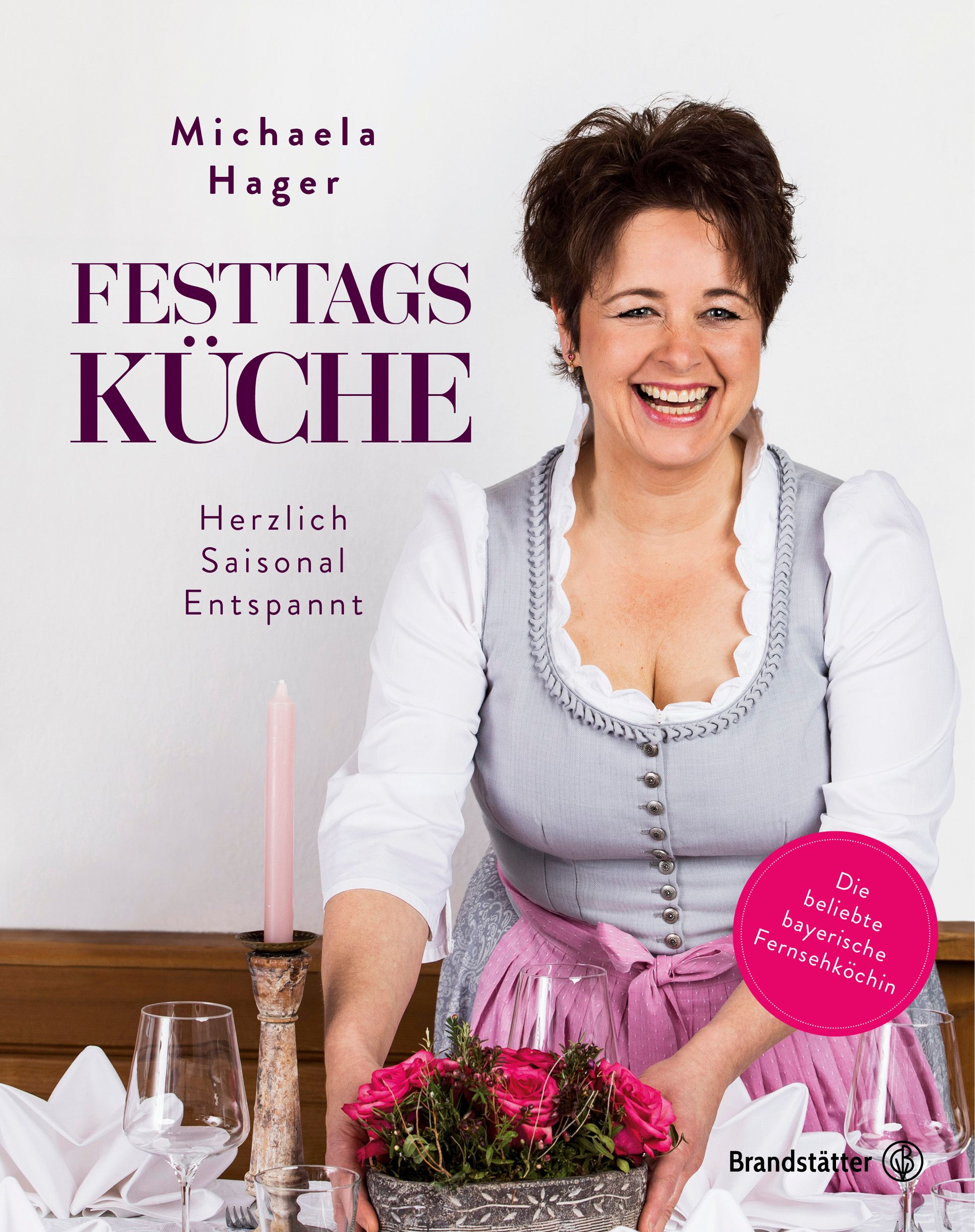 Buchcover mit Titel „Festtagsküche“ und Autorin Michaela Hager. Frau lächelt, hält Blumengesteck.