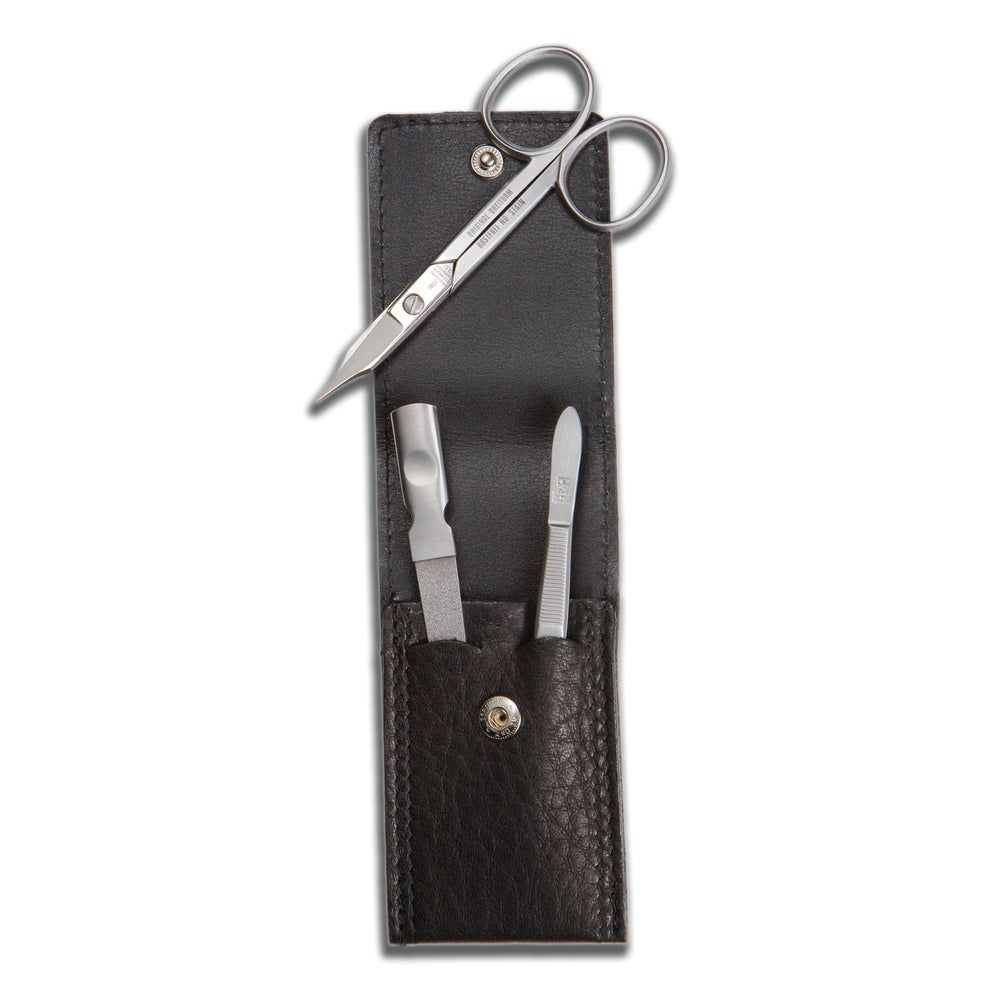 Maniküre-Etui mit Schere, Nagelfeile und Nagelheber. Schwarzes Lederetui mit Druckknopfverschluss. Werkzeuge aus Metall.