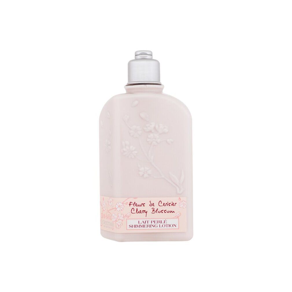 Rosa Flasche mit silbernem Deckel. Aufschrift: Fleur de Cerisier Cherry Blossom Lait Perlé Shimmering Lotion. Blumenmuster.