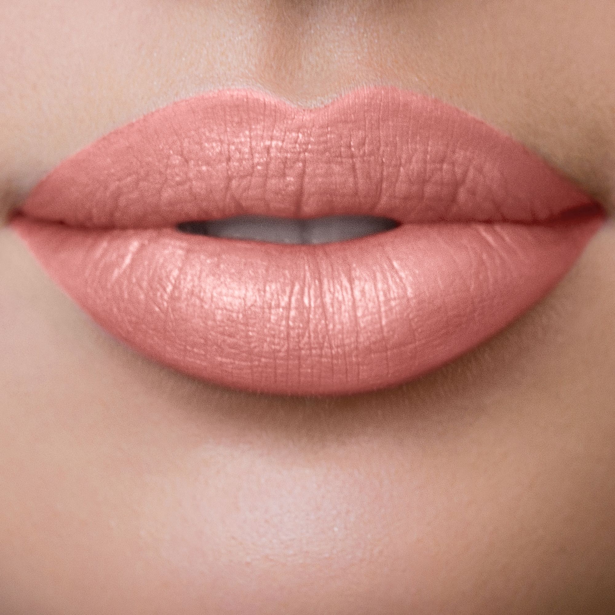 Nahaufnahme von Lippen, die mit rosafarbenem Lippenstift geschminkt sind. Die Lippen sind glänzend.