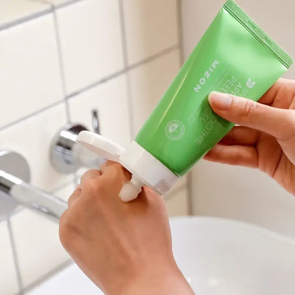 Grüne Tube mit Mizon Peel Gel, das auf eine Hand aufgetragen wird.