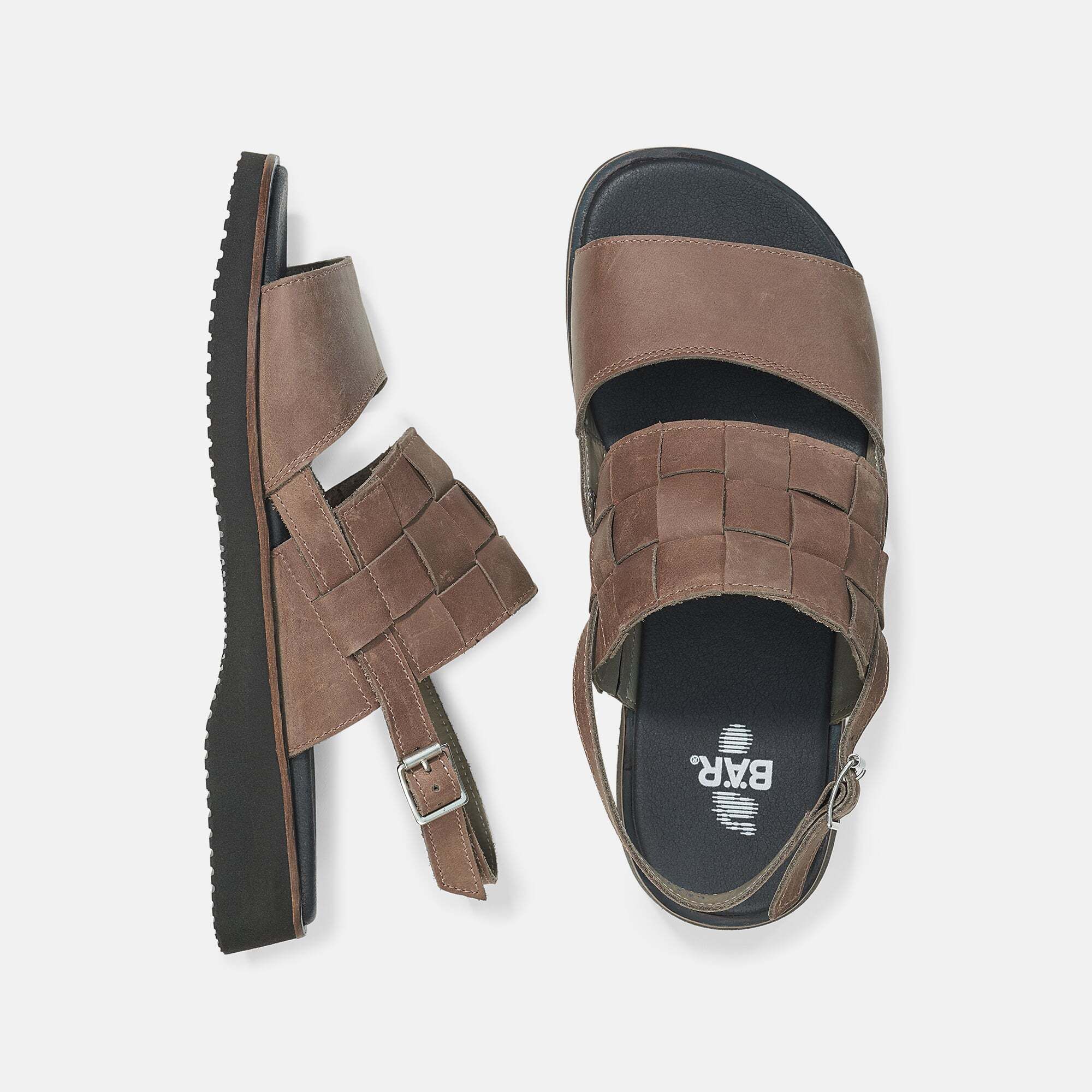 Zwei braune Sandalen, eine von oben, eine von der Seite. Geflochtener Riemen, schwarze Sohle, Schnalle.