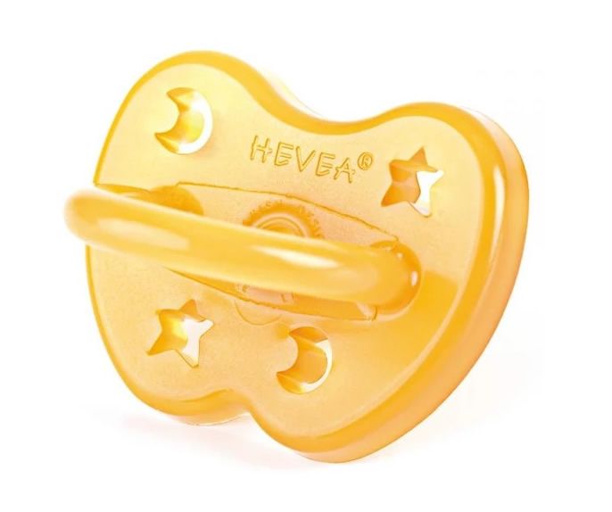 Gelber Schnuller mit Stern- und Mond-Aussparungen. Ringgriff. Marke Hevea.