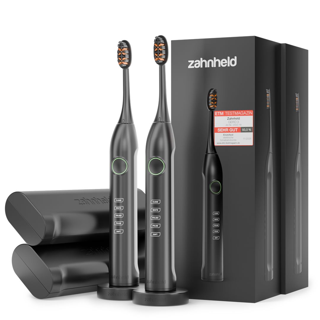 Doppelpack Zahnheld Schallzahnbürste Gero G3, schwarz, mit Etui und Ladestation. Aufsteller mit Produktabbildung und Testurteil.