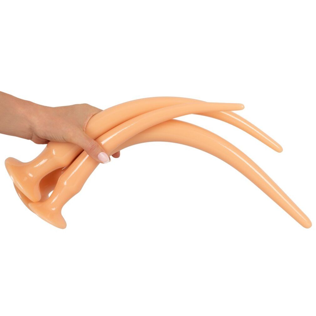 Hand hält zwei beige, gebogene Anal-Plug-Spielzeuge. Mit Basis.