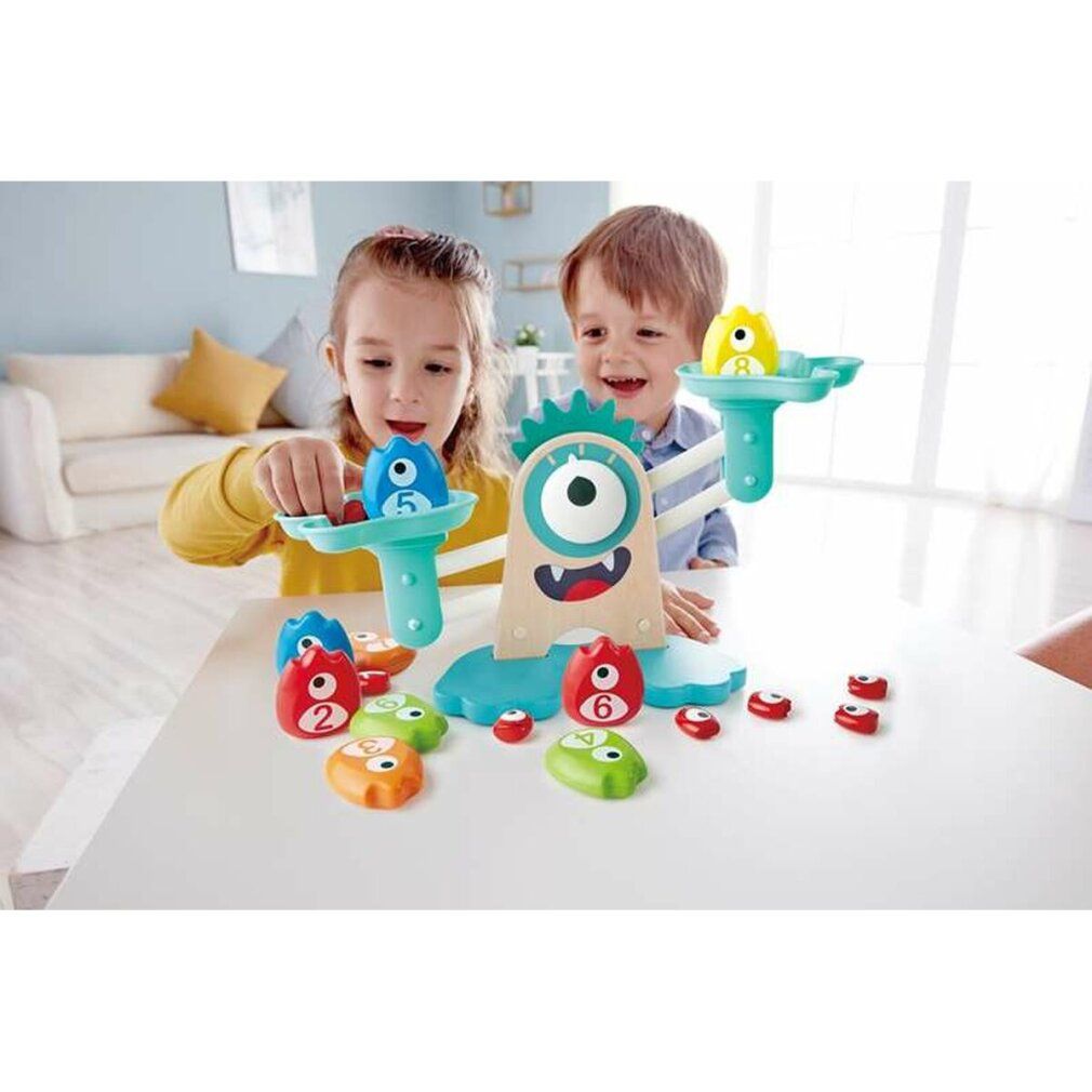 Kinder spielen mit der Monster-Waage. Verschiedene farbige Gewichte und Zahlen.