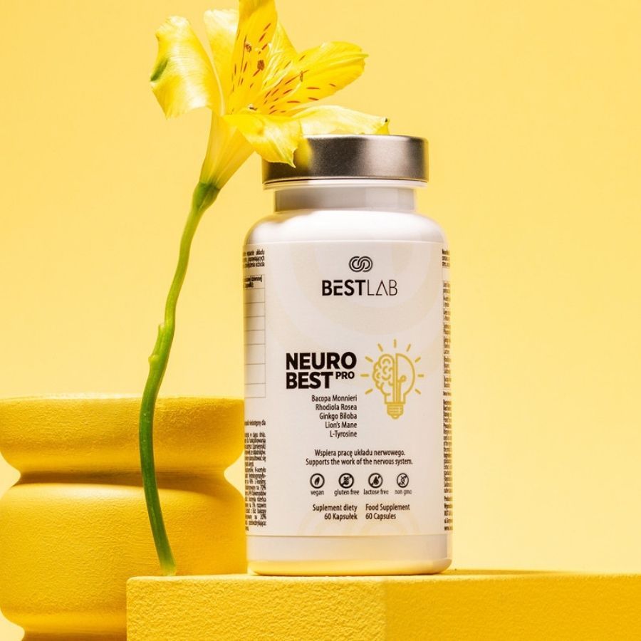 Weiße Flasche mit Kapseln neben gelber Blume und Gefäß. Aufschrift: BEST LAB NEURO BEST PRO. 60 Kapseln.