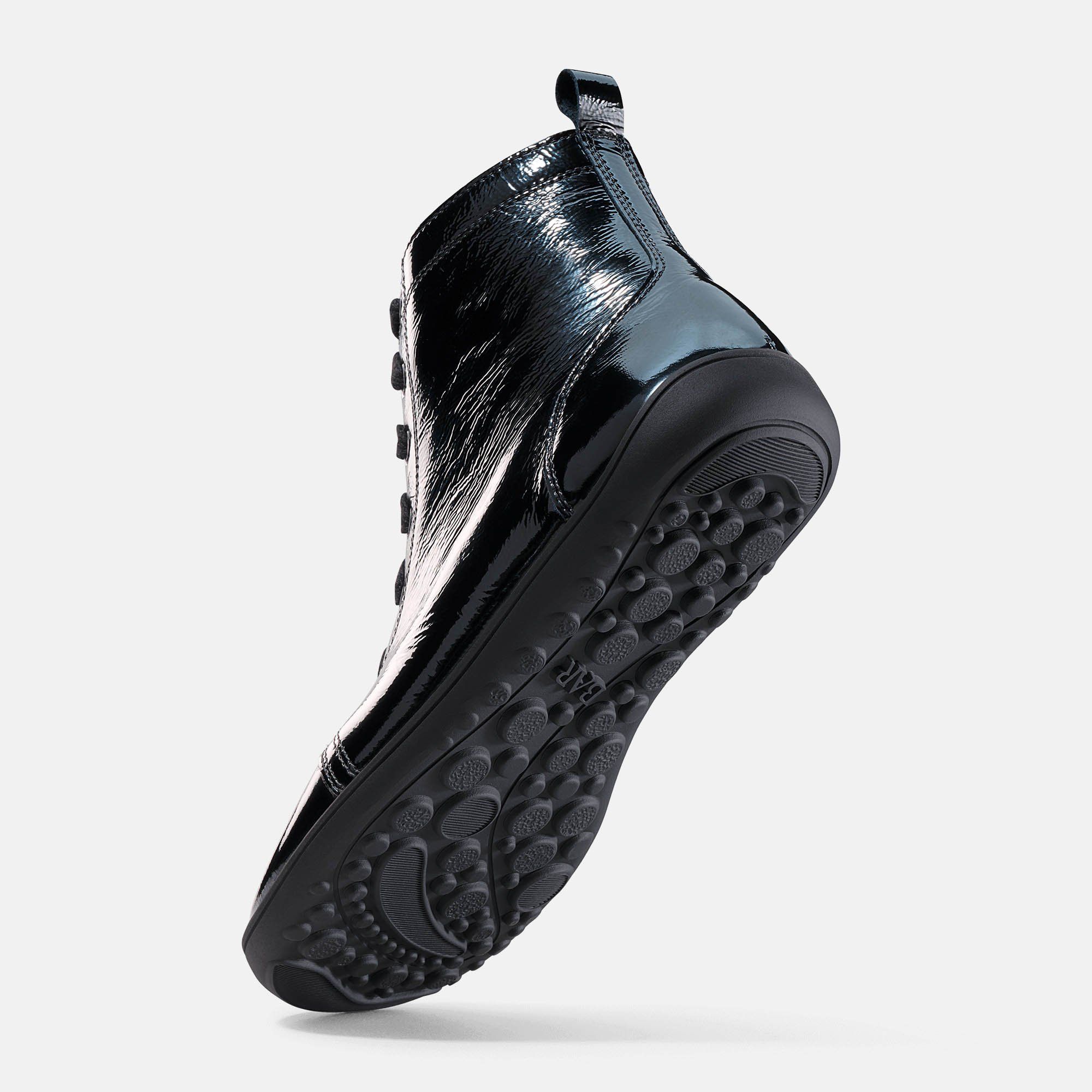 Schwarze Stiefelette. Glänzendes Obermaterial. Flache Sohle mit Profil. Unteransicht.