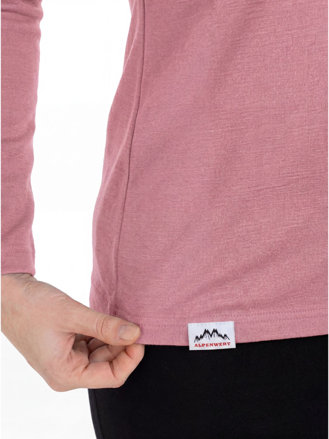 Detailansicht des Etiketts mit Alpenwert-Logo auf einem rosa Damen-Longsleeve aus Merinowolle.
