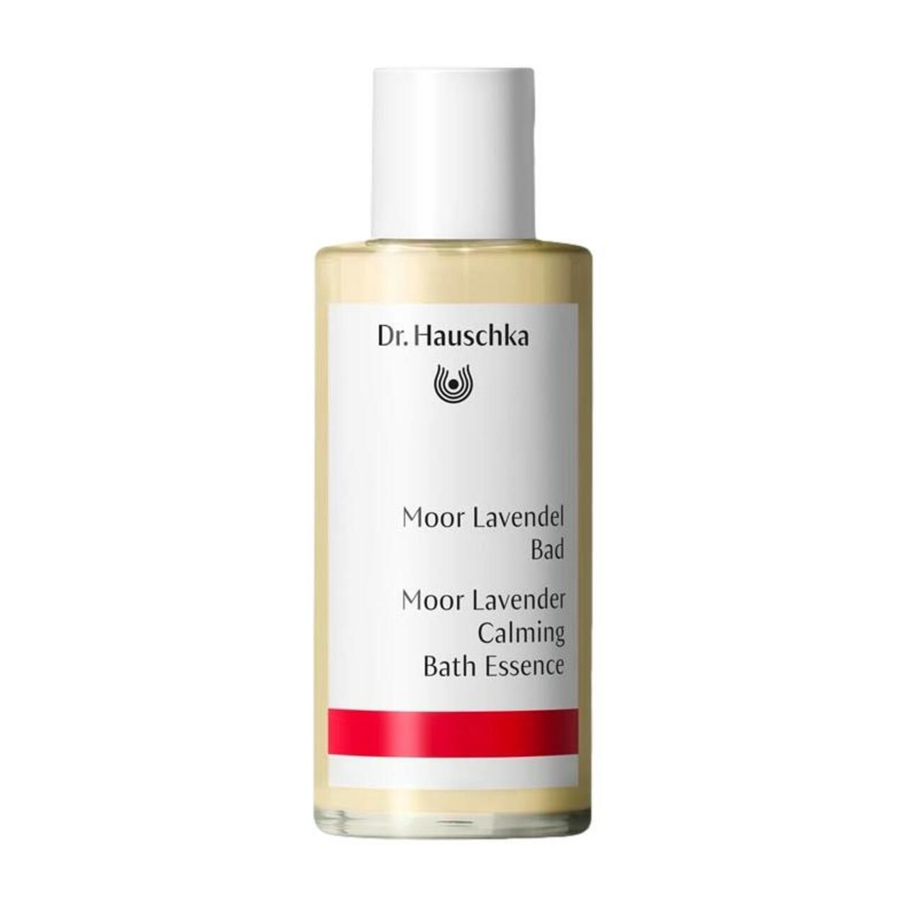 Flasche mit weißem Deckel. Etikett mit "Dr. Hauschka", "Moor Lavendel Bad", "Calming Bath Essence". Roter Streifen.