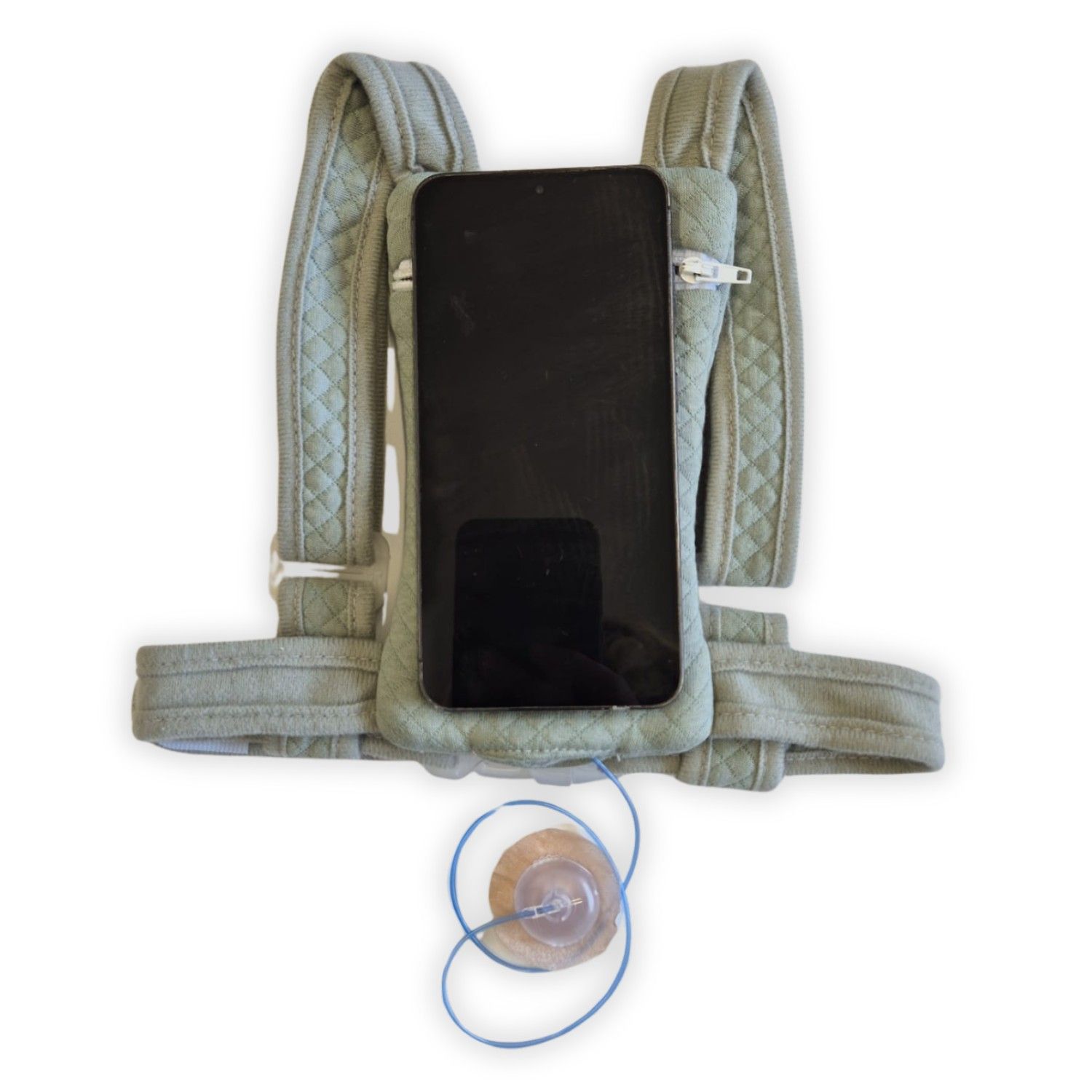 Grüner Rucksack mit Schultergurten und Reißverschlussfach. Smartphone und Insulinpumpe sichtbar.