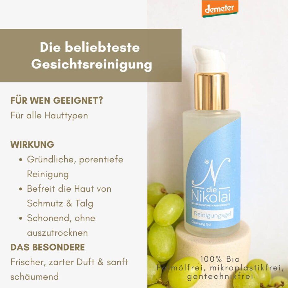 Klare Flasche mit weißem Pumpkopf und goldfarbenem Hals. Blaue Etikett mit Schriftzug. Demeter-Logo oben rechts. Trauben liegen daneben.