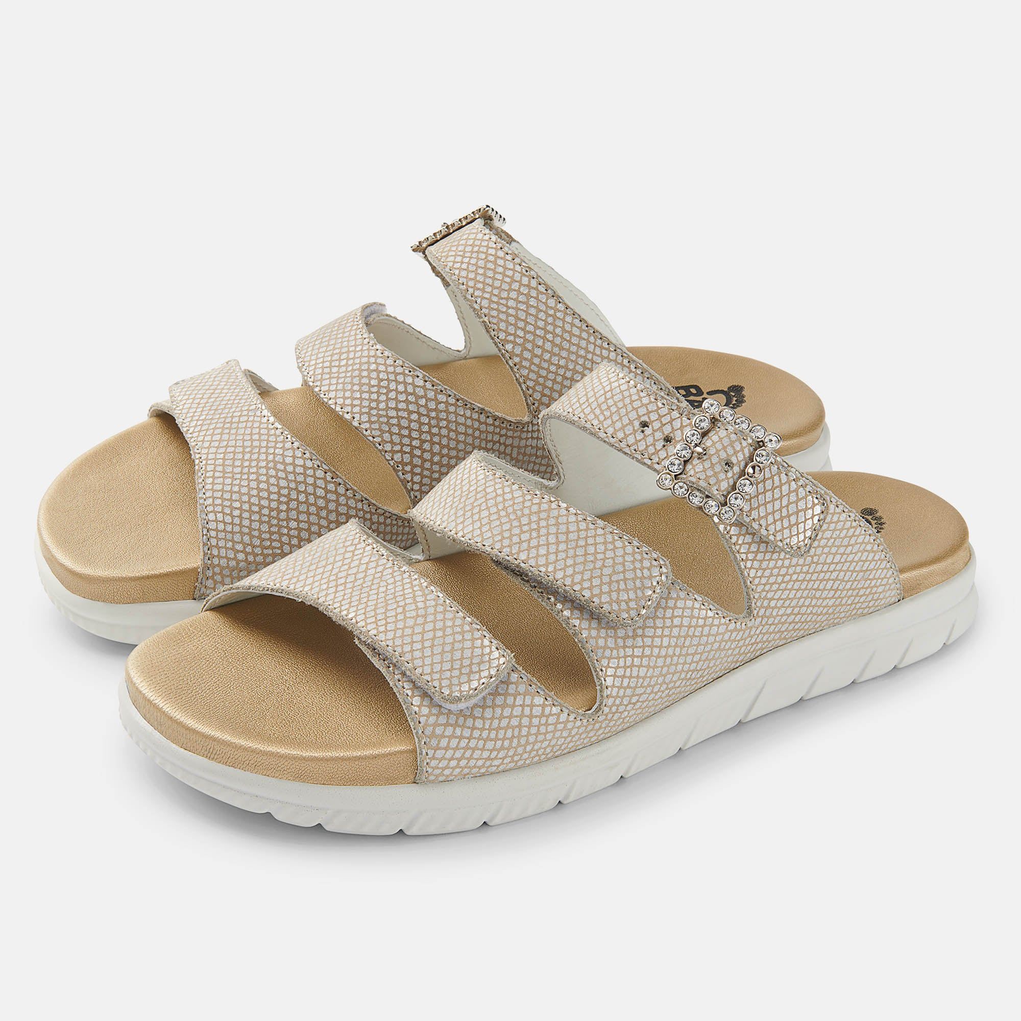 Beige Sandalen mit drei Riemen und Schnallen. Weiße Sohle, beiges Fußbett. Reptilienmuster auf den Riemen.