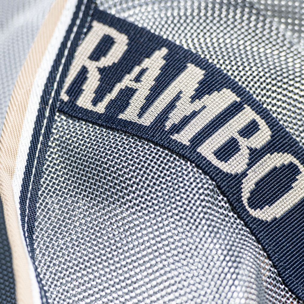 Detail der Rambo Protector Plus Decke. Logo 'Rambo' auf blauem Band. Hellgraues, gewebtes Material.