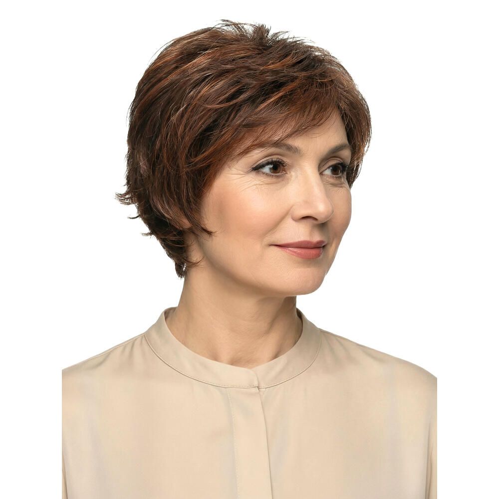 Nahaufnahme einer Frau mit kurzer, brauner Perücke mit roten Highlights. Die Frau trägt eine beige Bluse.