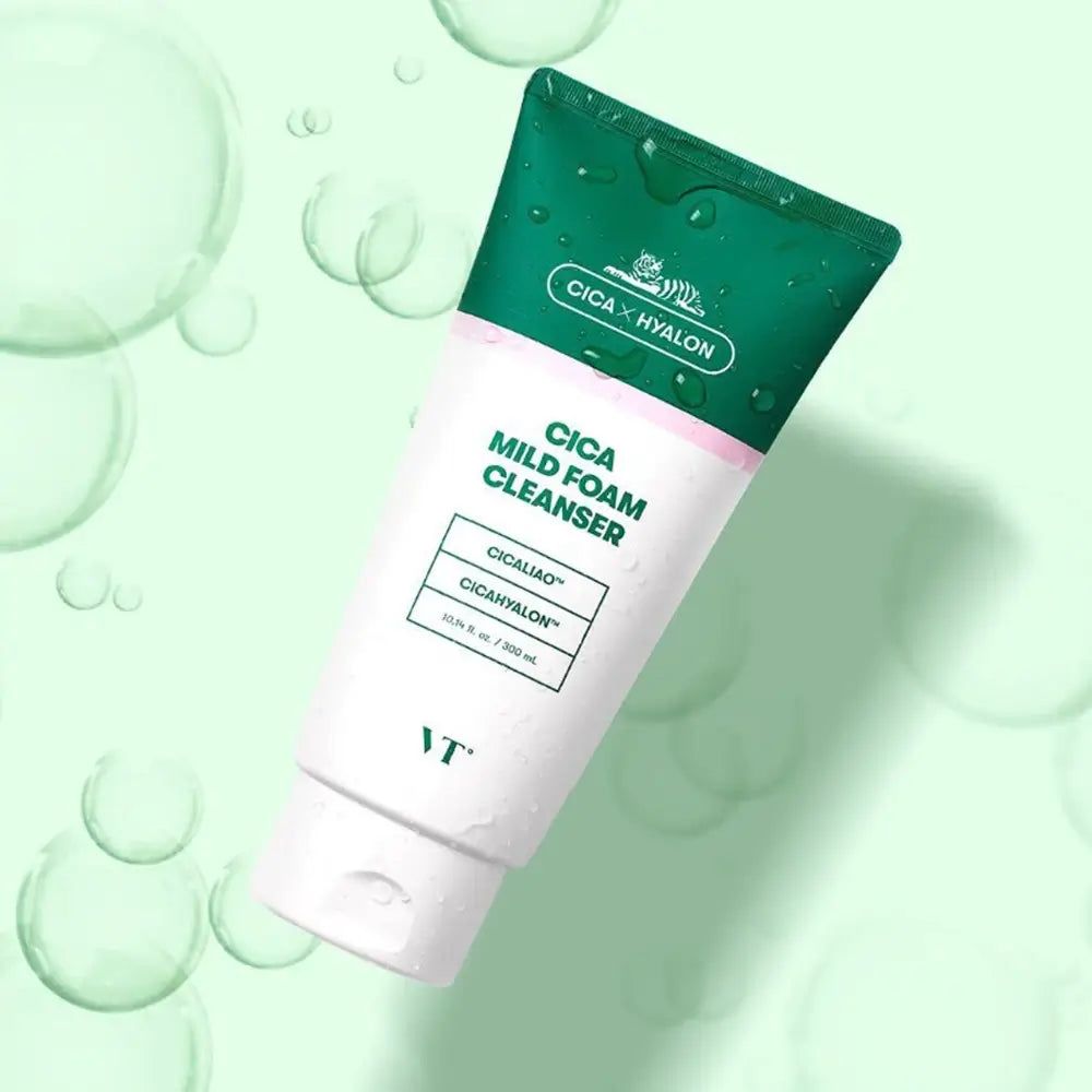 Weiße Tube mit grünem Deckel. Aufschrift: Cica Mild Foam Cleanser, Cicaliao, CicaHyalon. Marke: VT. Hintergrund mit Blasen.