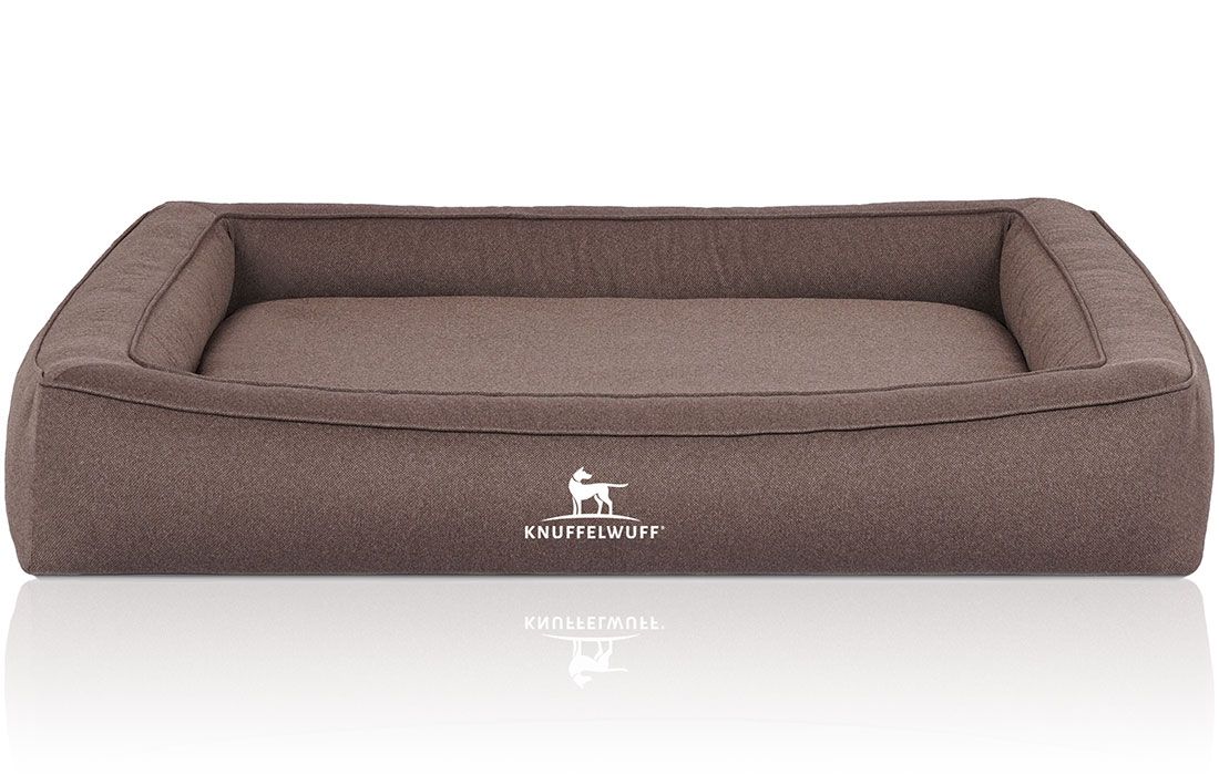 Braunes Hundebett mit erhöhtem Rand. Das Knuffelwuff-Logo ist auf der Vorderseite zu sehen. Rechteckige Form, Stoffbezug.