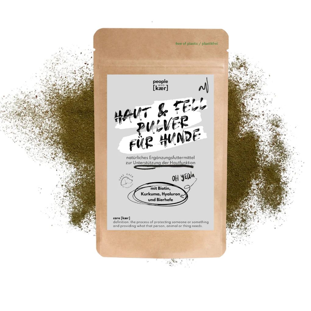 Beutel mit Produktnamen 'Haut & Fell Pulver für Hunde'. Text: 'natürliches Ergänzungsfuttermittel'. Enthält Biotin, Kurkuma, Hyaluron und Bierhefe.