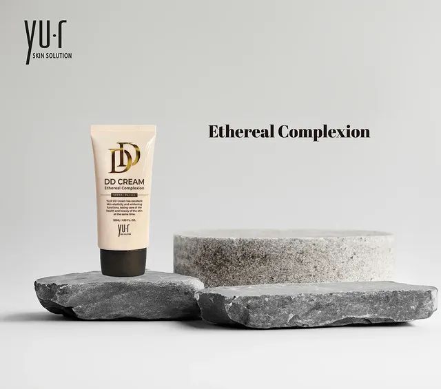 Tube auf Steinblöcken. Aufschrift: DD CREAM Ethereal Complexion. Marke: Yu.r Skin Solution. Text: Ethereal Complexion. Weißer Hintergrund.