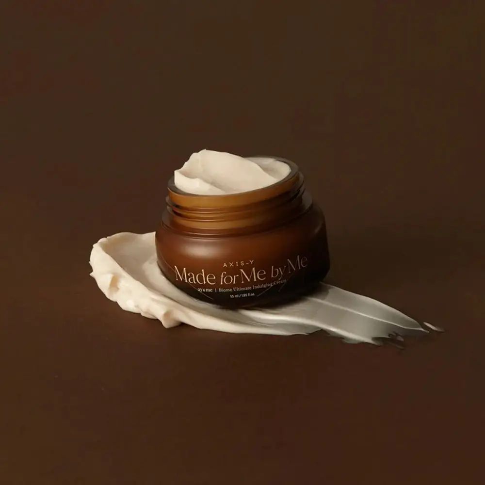 Braune Glascreme mit weißer Creme auf einer Spur Creme. Aufschrift: AXIS-Y, Made for Me by Me.