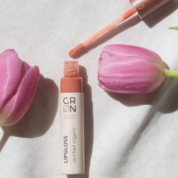 GRN Lipgloss mit Applikator und Tulpen. Flasche in Rosa- und Beigetönen. Aufschrift: LIPGLOSS, certified organic.