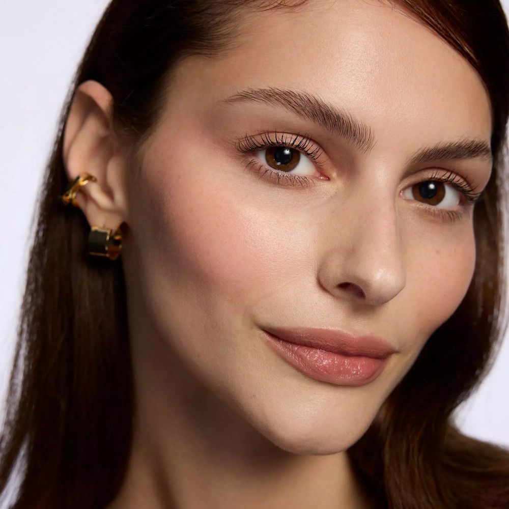 Porträt einer Frau mit Lippenstift. Sie trägt Ohrringe. Natürliches Make-up.