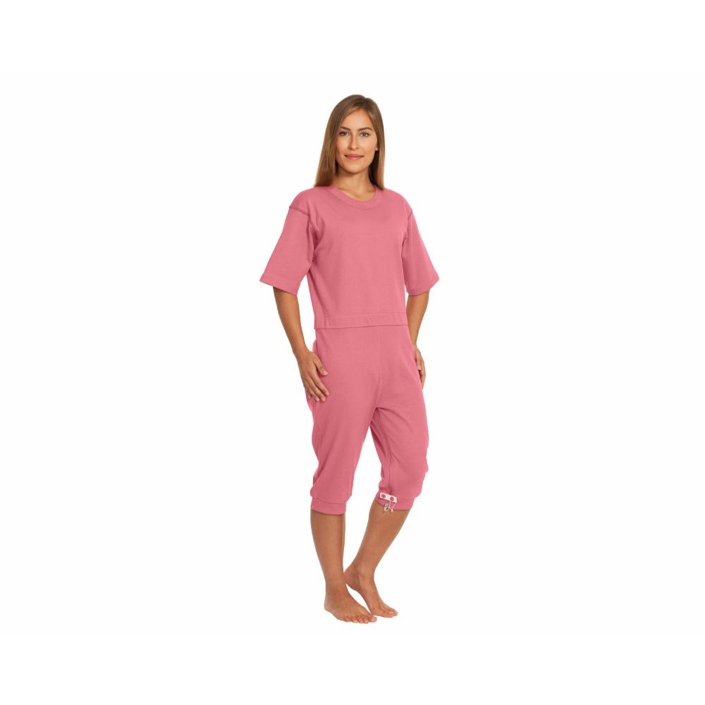 Rosa Pflegeoverall kurz. Kurzarm, Dreiviertel-Hose. Eine Frau trägt den Overall. Detail am Bein.