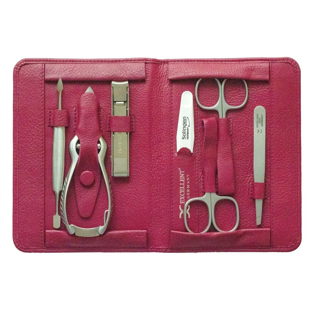 Geöffnetes Maniküre-Etui mit sieben Teilen. Enthalten: Nagelschere, Feile, Pinzette, Nagelknipser, etc. Geprägt: EXCELLENT GERMANY.