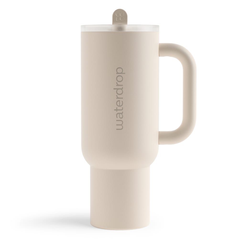 Beige Thermobecher mit Henkel und Deckel. Vertikaler Schriftzug waterdrop®. Zylindrische Form mit breiterem Boden.