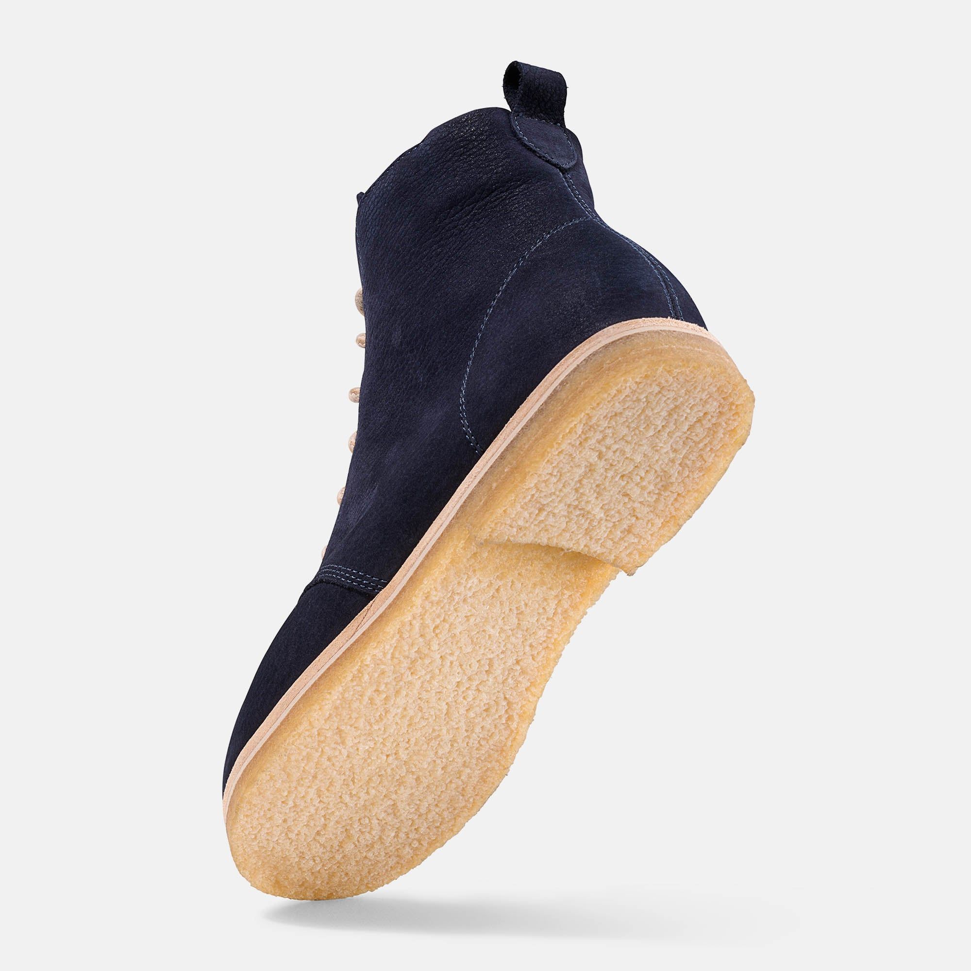 Dunkelblaue Stiefelette mit beiger Sohle. BÄR-Logo am Schaft. Schuh von unten und Seite.