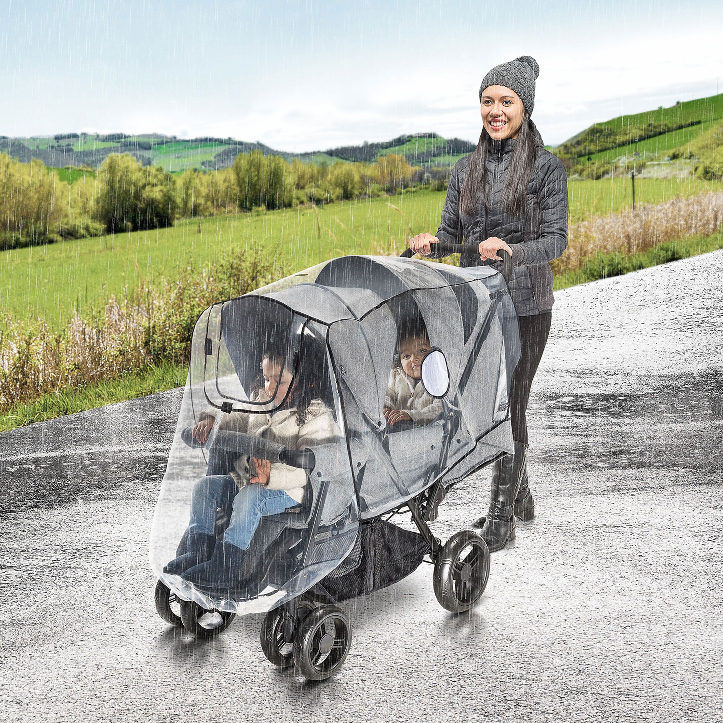 Eine Frau schiebt einen Kinderwagen mit Regenschutz im Regen. Der Regenschutz ist transparent.
