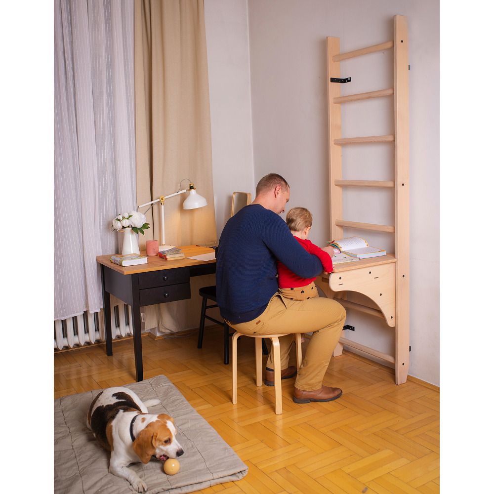 Mann und Kind am Schreibtisch des Holz-Klettergerüsts.
