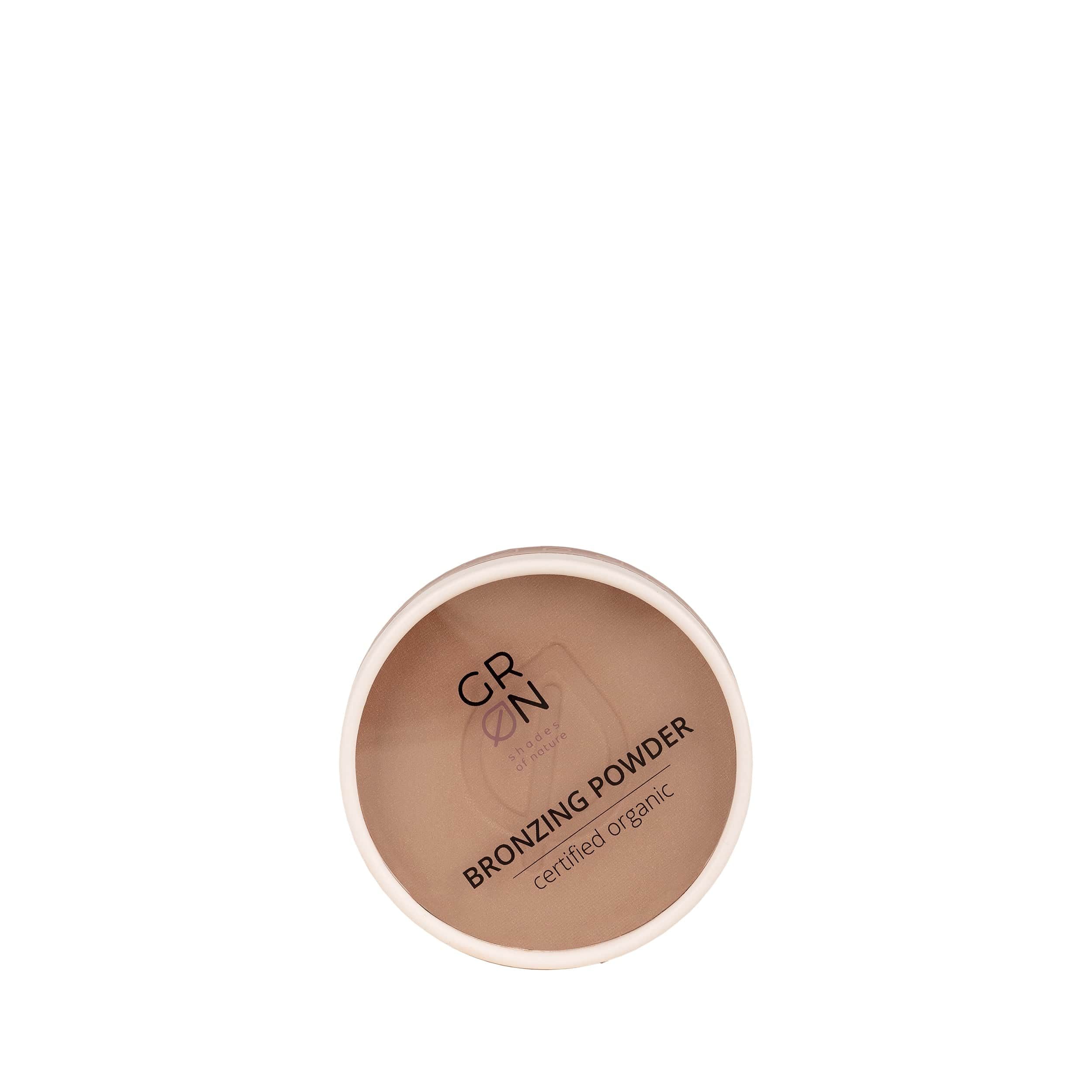Runder Behälter mit braunem Bronzing Powder. Aufschrift: GRN Bronzing Powder certified organic. Weißer Rand.
