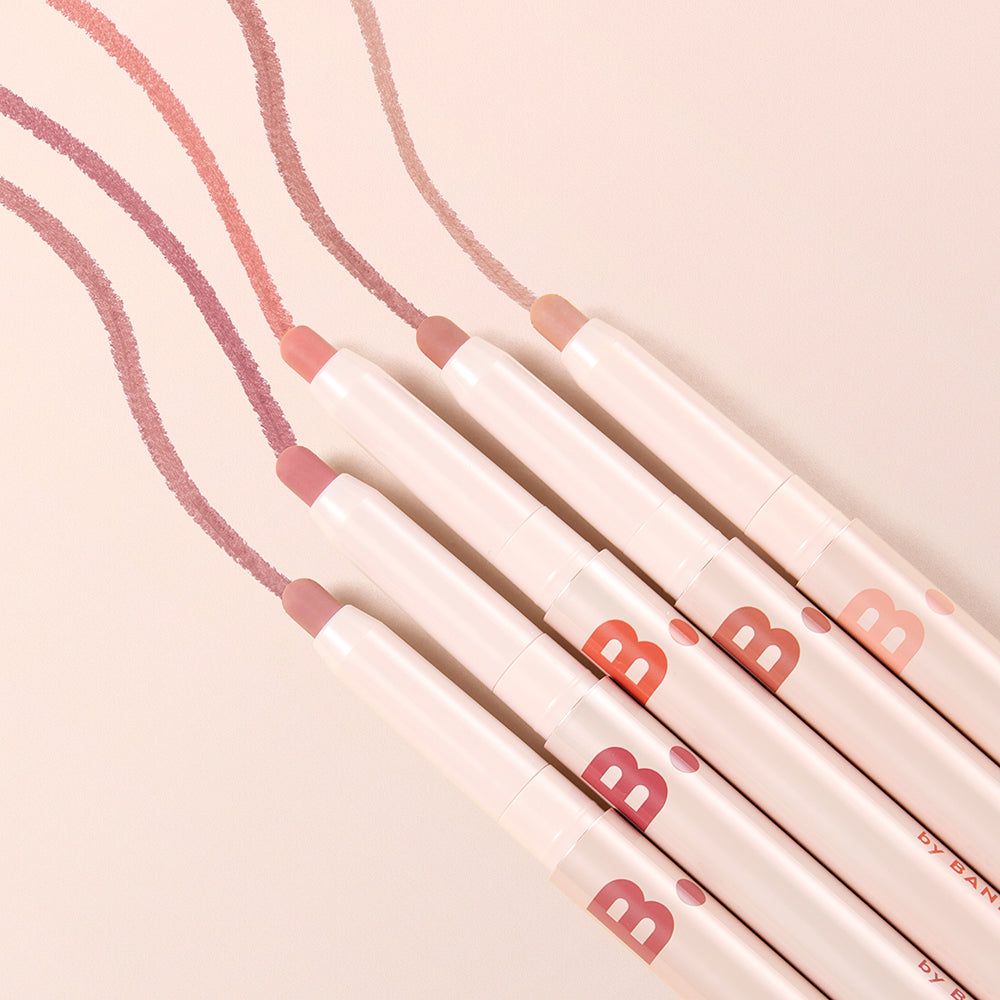 Sechs Lipliner in Pastelltönen mit sichtbaren Farbstrichen. Die Stifte sind weiß mit rosa und orangefarbenen Markierungen.