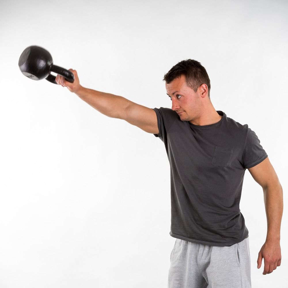 Mann mit schwarzer Kettlebell. Graues T-Shirt und Hose. Weißer Hintergrund.