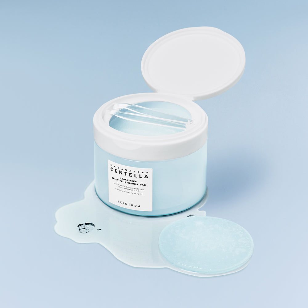 Hellblaue Dose mit Centella Ampoule Pads, ein Pad liegt daneben.