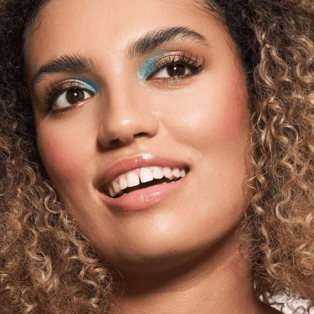 Porträt einer Frau mit Make-up. Blaue Lidschatten, rosa Lippen. Kosmetisches Produkt.