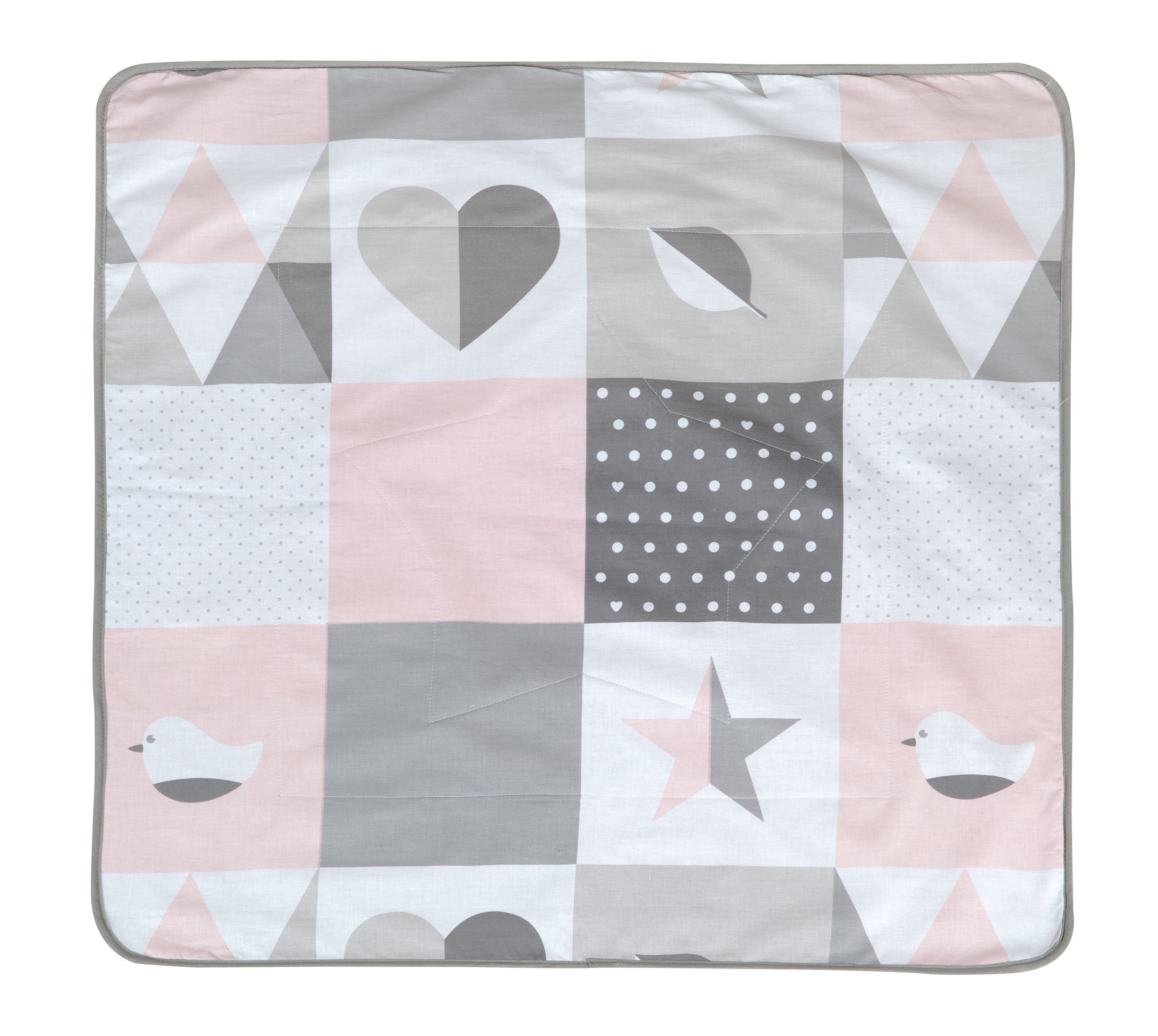Kuscheldecke mit Patchwork-Design. Rosa, grau und weiße Quadrate mit geometrischen Formen und Vögeln. Grauer Rand.