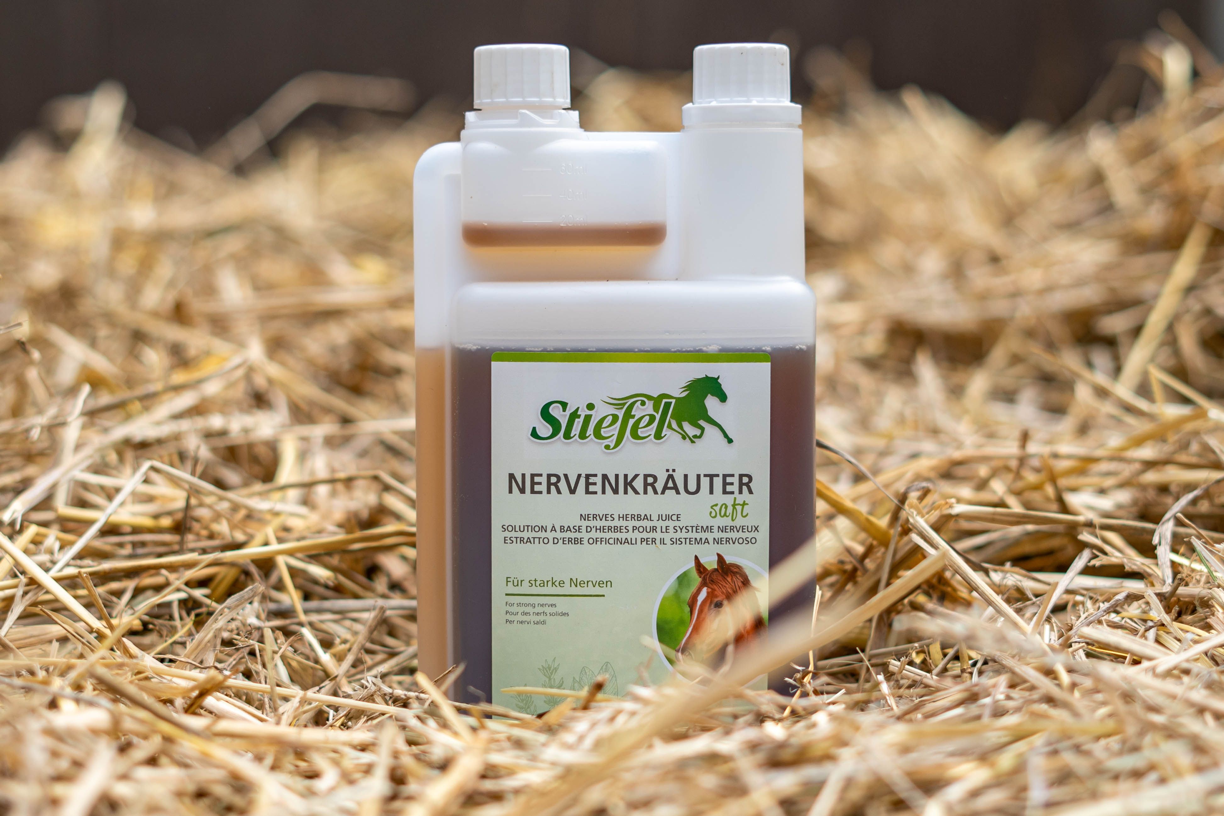 Flasche Stiefel Nervenkräutersaft auf Stroh. Weiße Flasche mit brauner Flüssigkeit. Grünes Etikett mit Logo und Produktnamen.