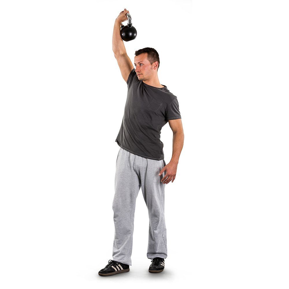 Mann hebt eine 4kg Kettlebell über den Kopf, Arm gestreckt.