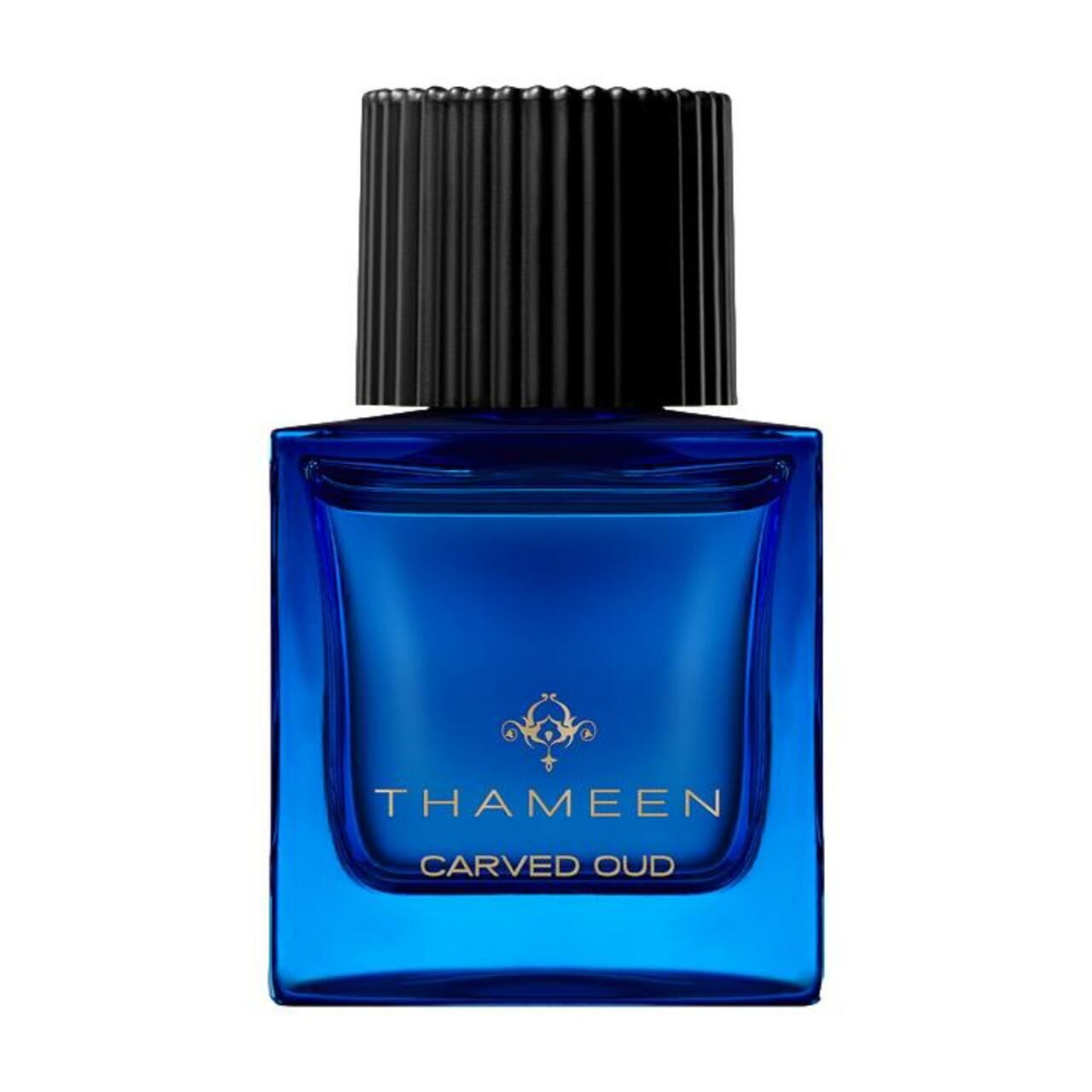 Blauer Flakon mit schwarzem Verschluss. Aufschrift: Thameen, Carved Oud. Goldene Verzierungen.