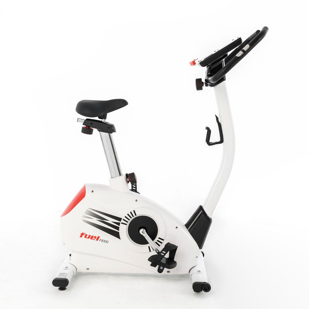 Ergometer, weiß mit roten Akzenten. Schwarzer Sattel und Lenker. FUEL-Logo. Pedale und Halterung.