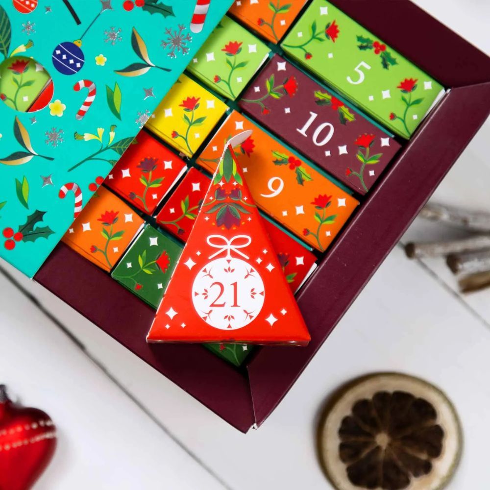 Adventskalender mit geöffneter Box. Pyramiden-Teebeutel mit Zahlen. Weihnachtsdesign.